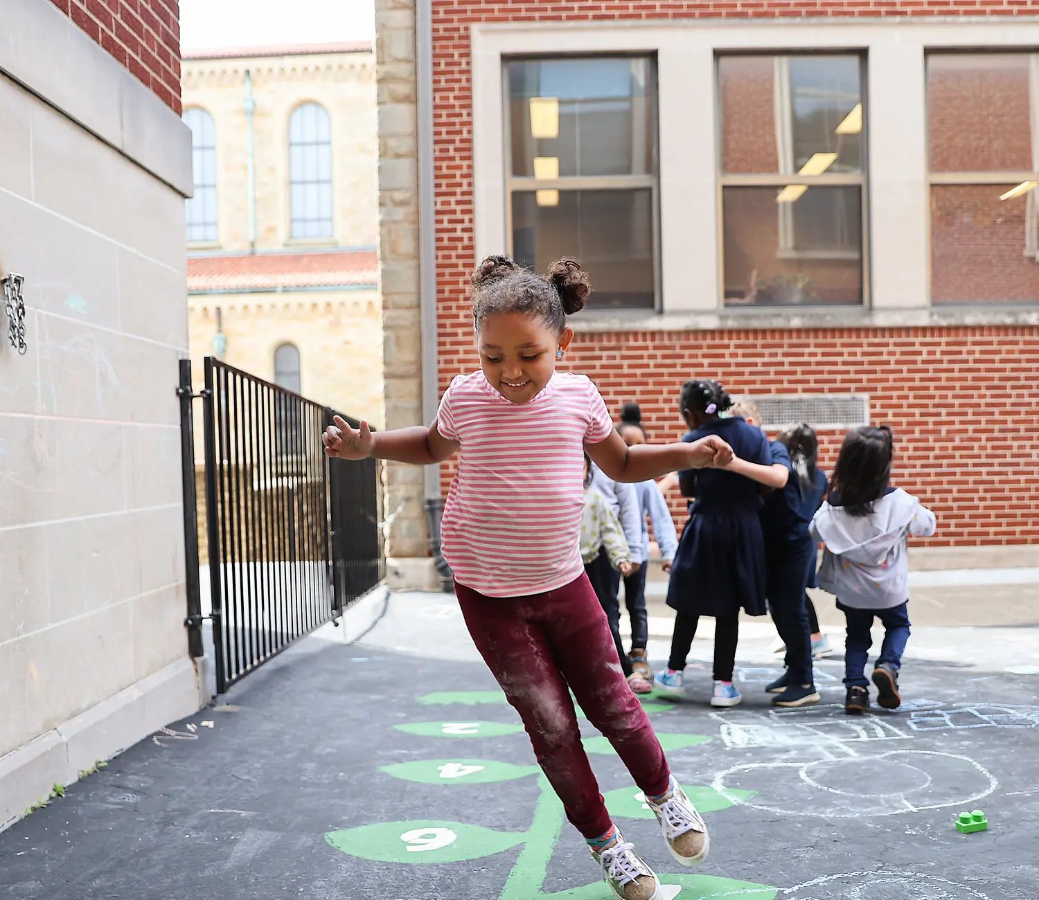 Female student playing outside school building