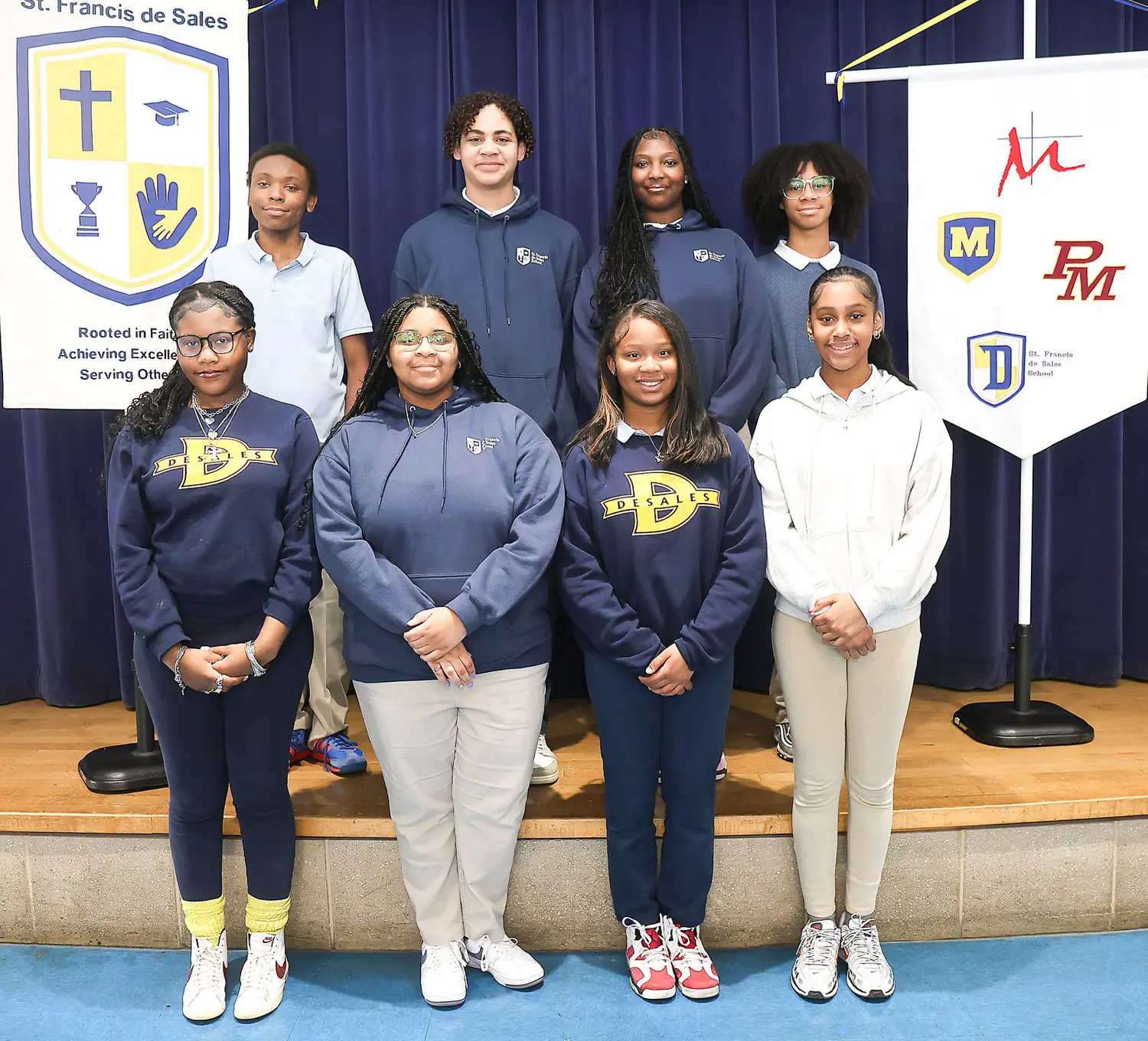 Group of high school students standing next to school banners