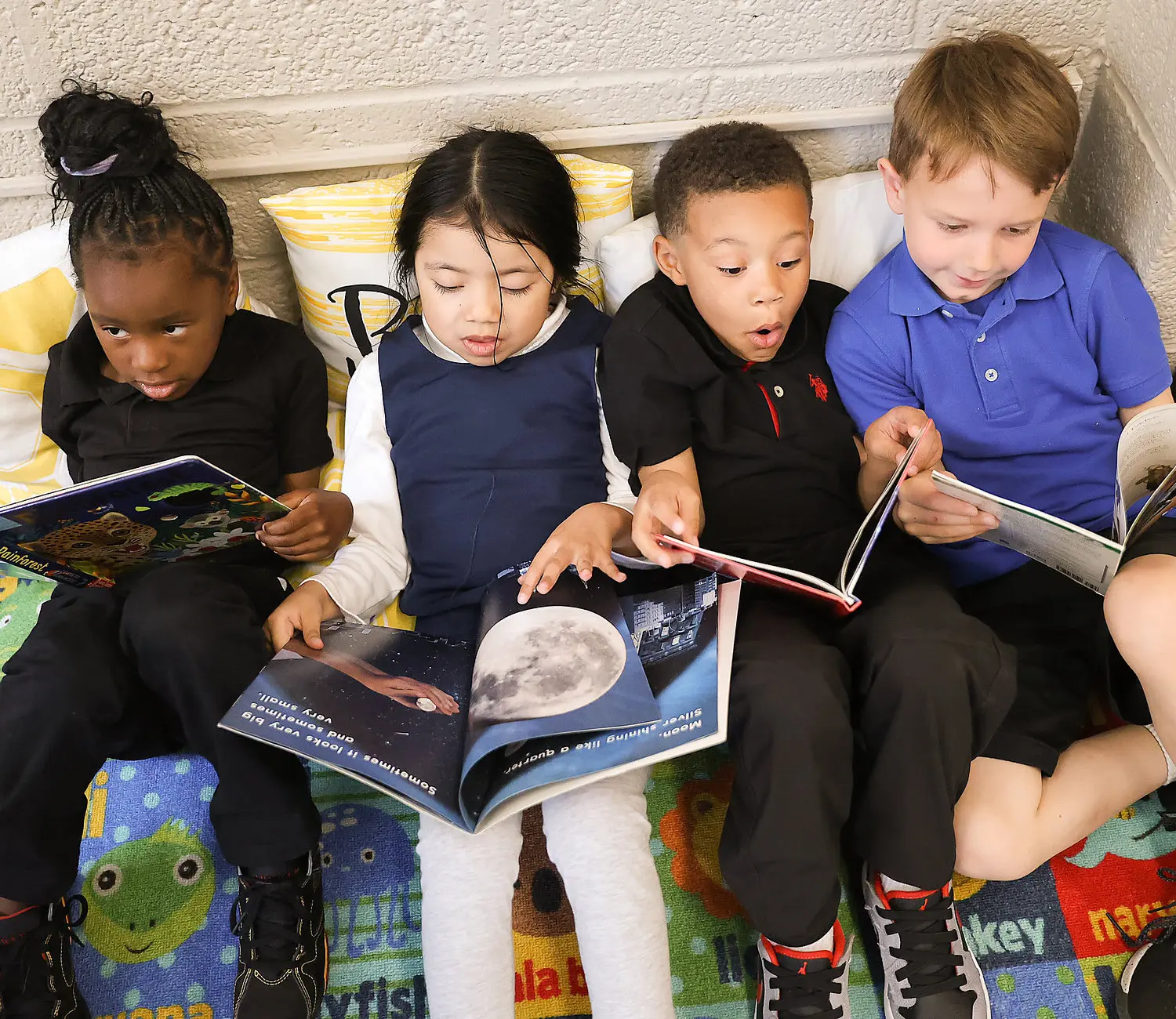 Elementary school students sitting in group reading books