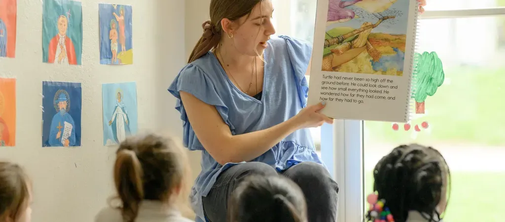 Teacher reading book to group of students