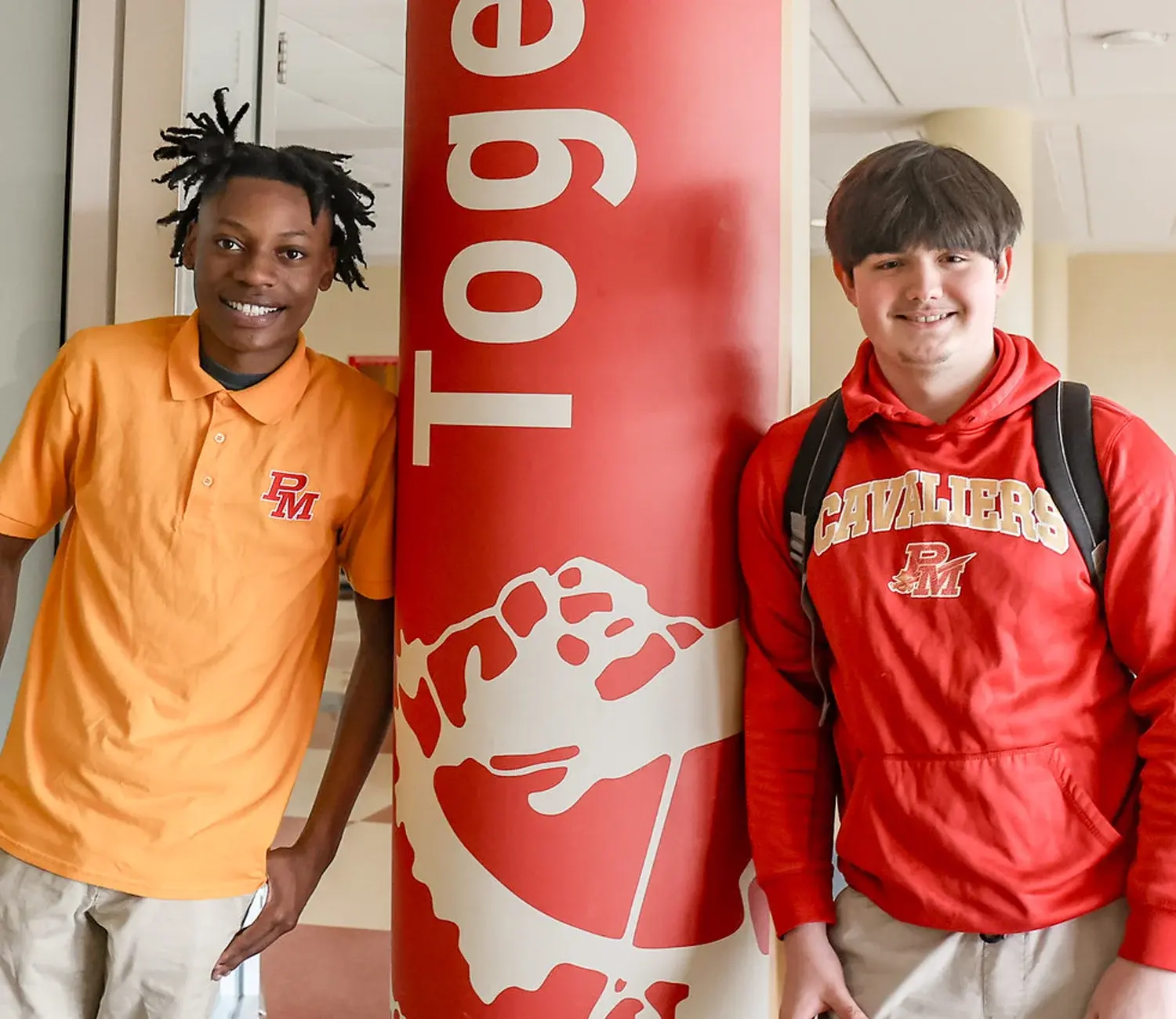 Two male high school students leaning against column