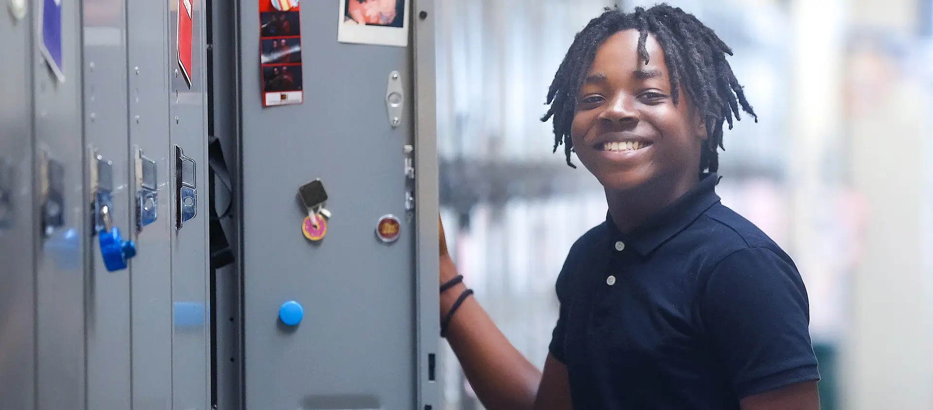 Male student standing at open locker