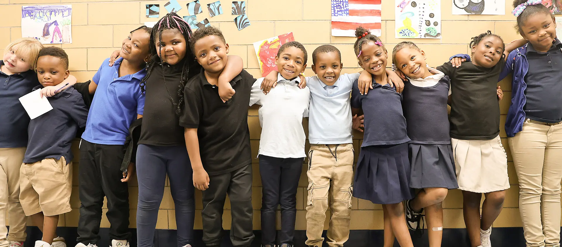 Elementary school students in a standing along with artwork