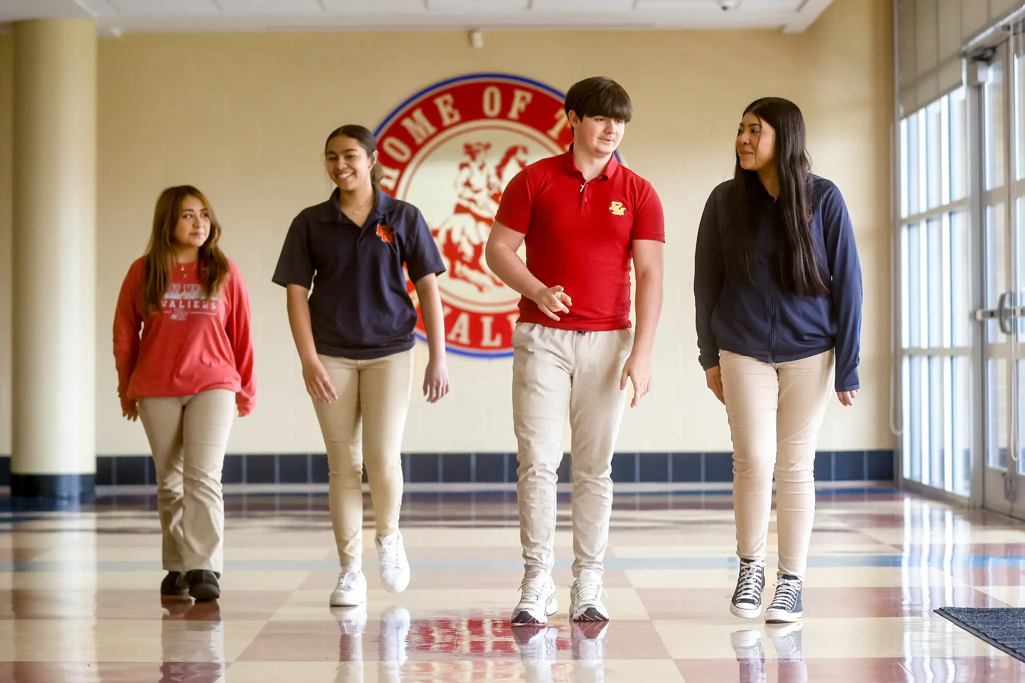 Four high school students standing in hallway