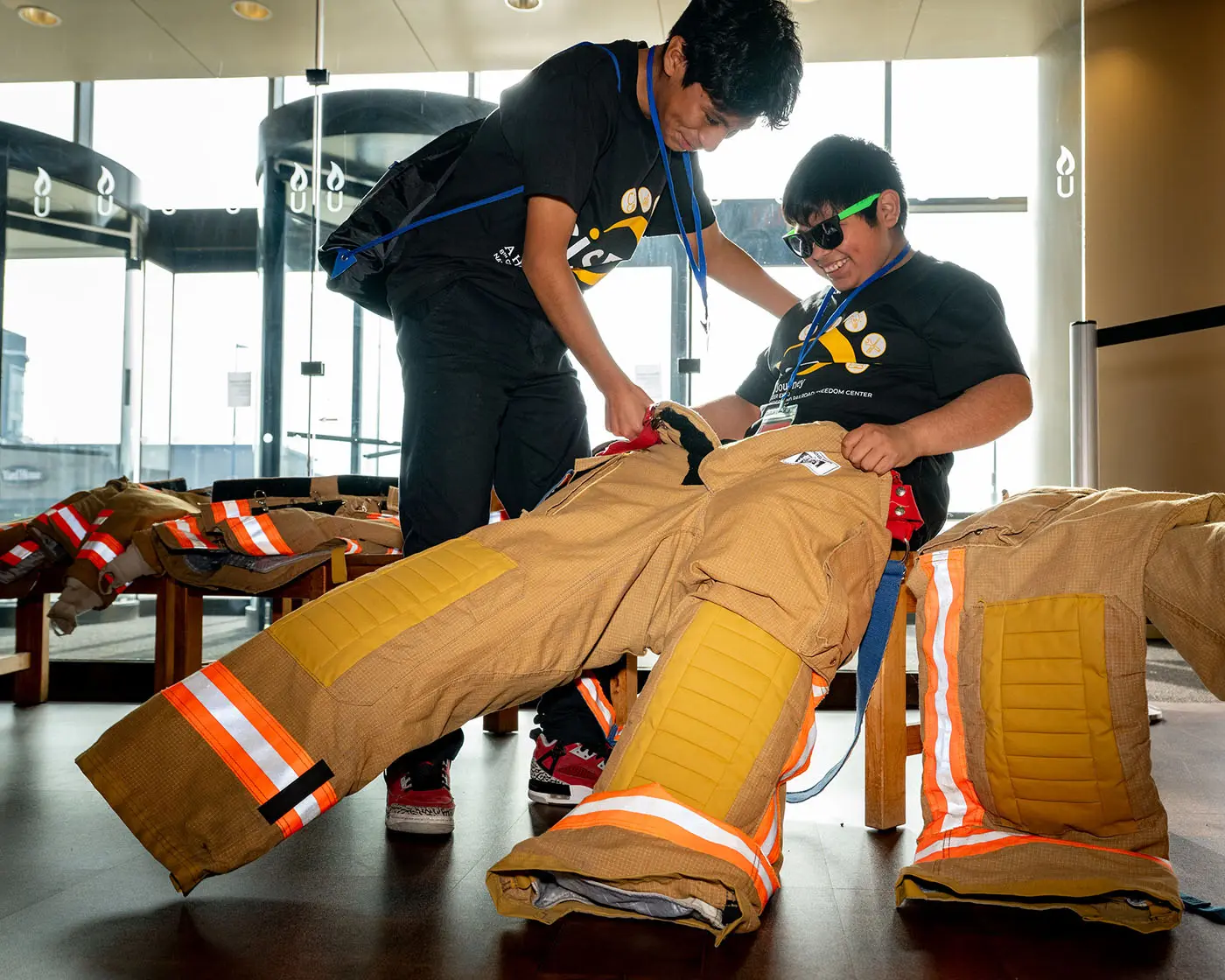 Two students trying on fire fighter suits